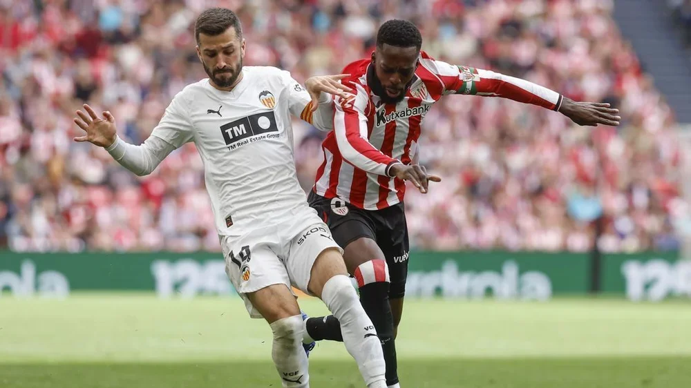 El defensa del Valencia José Luis Gayá controla el balón ante Iñaki Williams del Athletic